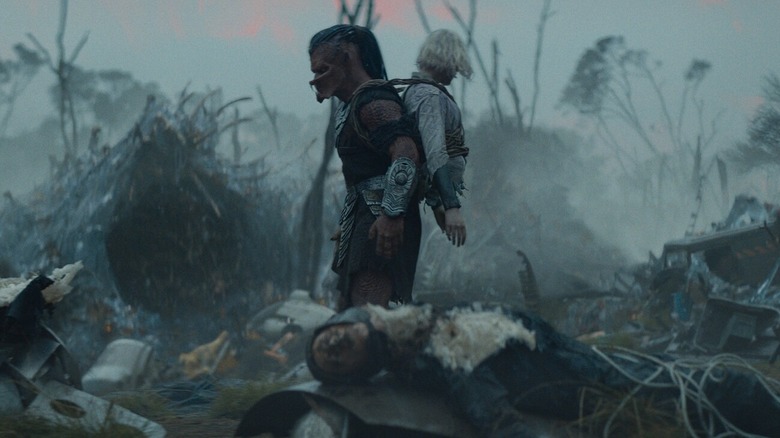 Dek care se plimba printr -un pustiu extraterestru cu Thia legată de spate în Predator: Badlands