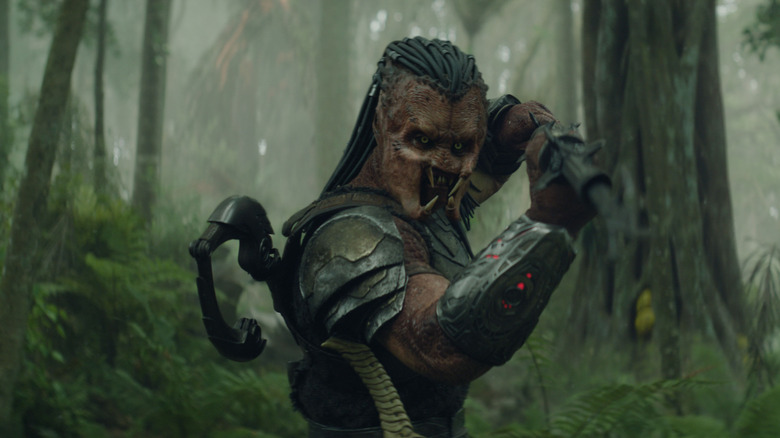 Dek ținându -și arma în poziție verticală în Predator: Badlands