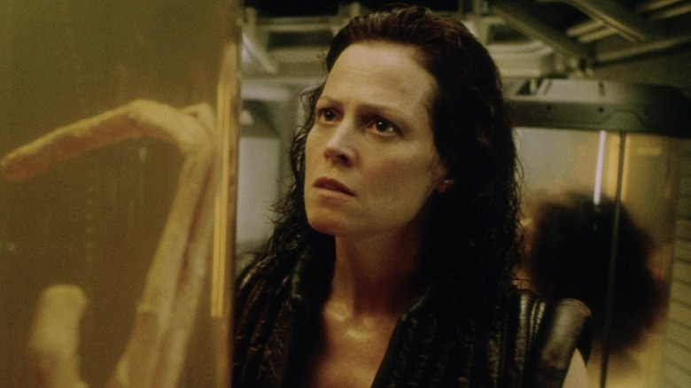 Sigourney Weaver în rolul lui Ellen Ripley privind un extraterestru într -un rezervor din Alien: Învierea