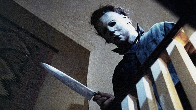 Michael Myers aplecat peste balustrada scării în Halloween (1978)
