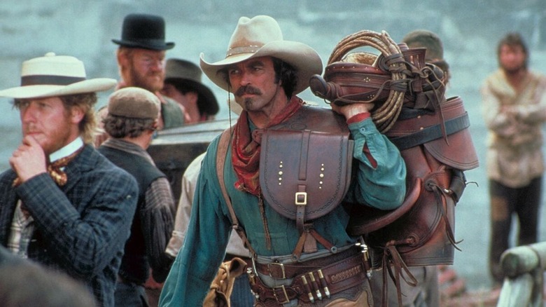 Quigley ținând o șa în Quigley Down Under