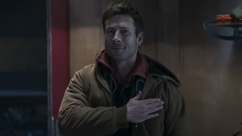 Ben își pune mâna peste inimă în timp ce se uită la soția și fiica sa în The Running Man