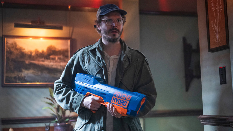 Elton Parrakis (Michael Cera) electrocutează bucuros o grămadă de vânători cu un pistol cu ​​apă în The Running Man