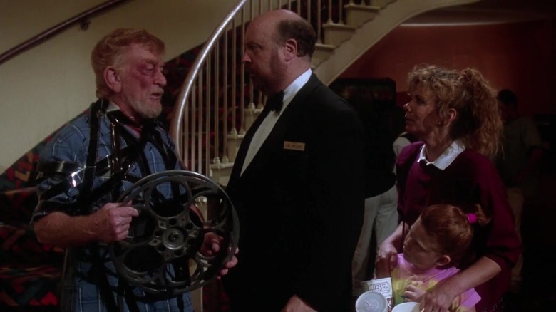 Un proiectionist însângerat care vorbește cu un manager de teatru și cu un părinte în Gremlins 2: The New Batch