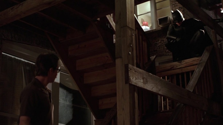 Gary Oldman în rolul lui Jim Gordon și Christian Bale în rolul lui Batman se întâlnesc în fața unui bloc de apartamente din Batman Begins