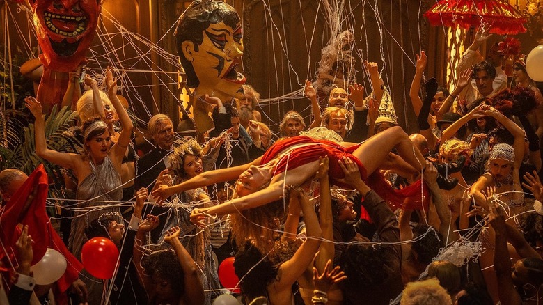 Margot Robbie în rolul Nellie LaRoy fiind purtată la o petrecere în Babilon