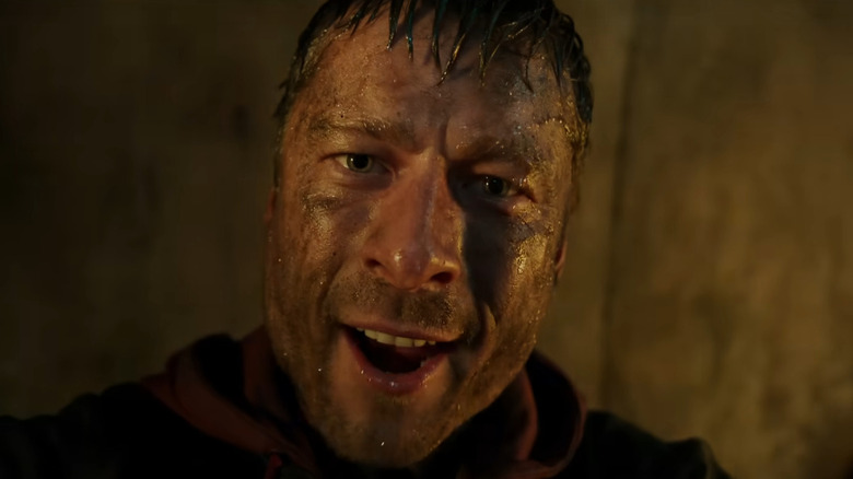 Ben Richards se adresează camerei în timp ce este acoperit de apă de canalizare în The Running Man