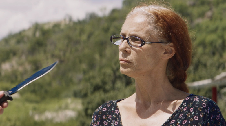 Sônia Braga în timp ce Domingas se confruntă cu un cuțit ținut de cineva care stă în afara ecranului în Bacurau