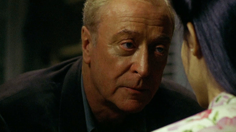 Thomas Fowler de la Michael Caine se apropie în timp ce vorbește cu Phuong de la Do Thi Hai Yen în The Quiet American