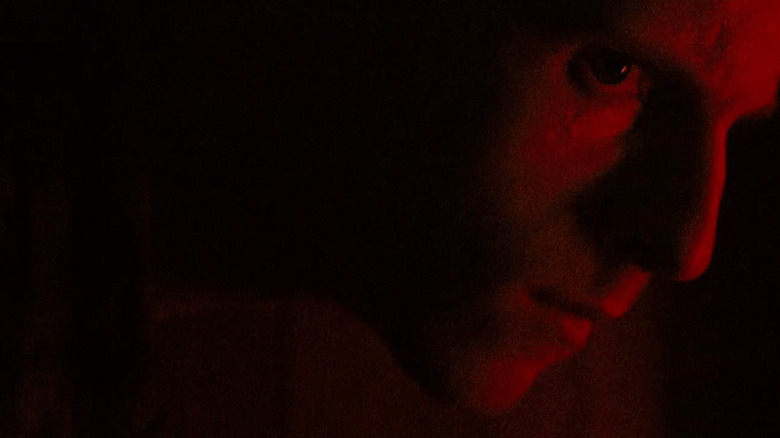 Jamie Bell's Pvt. Jack Corman este văzut în prim-plan iluminat de lumină roșie în Retreat