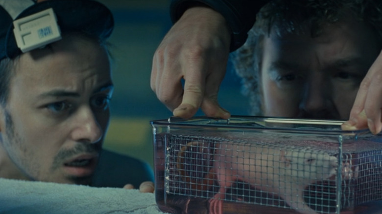 Todd Graff în rolul lui Hippy și Leo Burmester în rolul Somnului privind un șobolan care respiră lichid într-o cușcă în Abyss