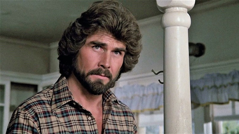 James Brolin ca George Lutz stând în dormitor în The Amityville Horror (1979)