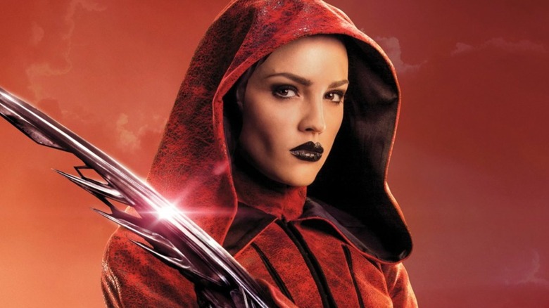 Nyssiana purtând o glugă roșie și mânuind o lamă de braț într-un poster Alita: Battle Angel