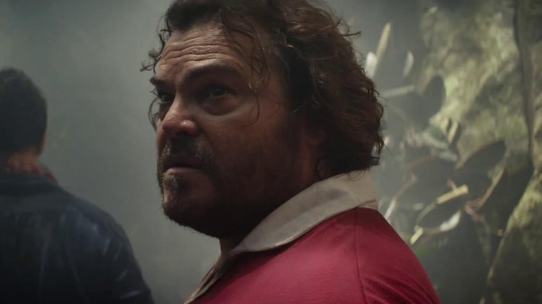 Jack Black ca Doug privind peste umăr în junglă în Anaconda (2025)