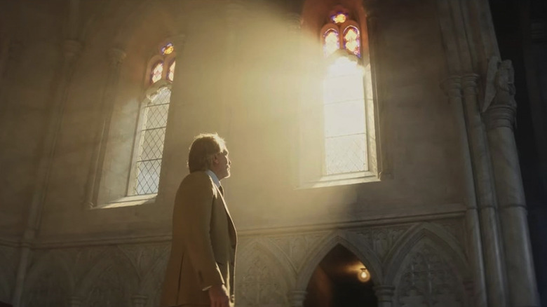 Benoit Blanc, scăldat în lumina soarelui care pătrunde prin fereastra unei biserici, în Wake Up Dead Man