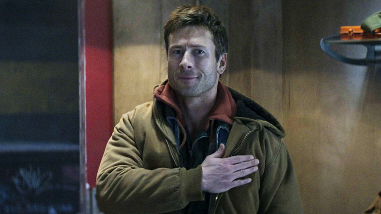 Ben Richards din Glen Powell își ține mâna peste inima în The Running Man