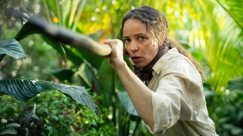 Rachel McAdams ca Linda ținând un băț în timp ce vânează un mistreț în Trimiteți ajutor