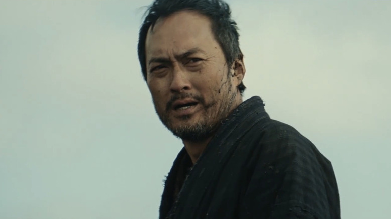 Jubei Kamata al lui Ken Watanabe se uită în depărtare pe un cer gri în Unforgiven