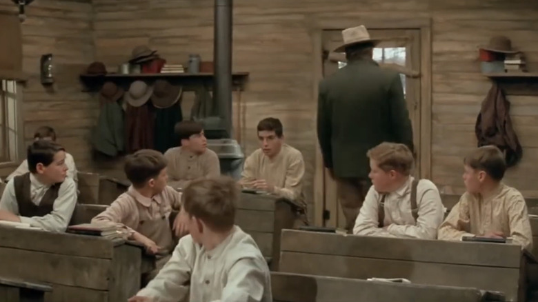 Toți școlarii se întorc să-l privească pe Wil Andersen al lui John Wayne ieșind din sala de clasă în The Cowboys