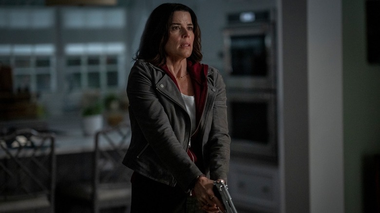 Neve Campbell ca Sidney Prescott cu un pistol scos în bucătărie în Scream 7
