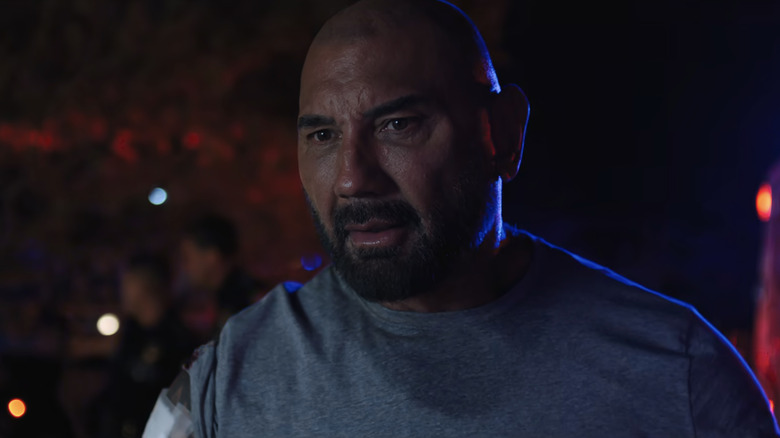 Ray Seale al lui Dave Bautista stă afară, iluminat de luminile poliției, în Trap House