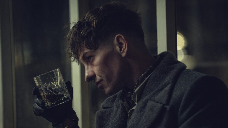 Barry Keoghan ca Erasmus ținând un pahar de whisky în Peaky Blinders: The Immortal Man