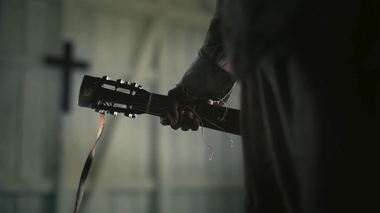 Sammie își ține chitara ruptă în Sinners