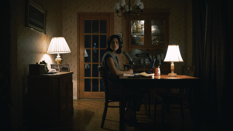 Evy se uită nervoasă în jur în timp ce podcastează sub ton