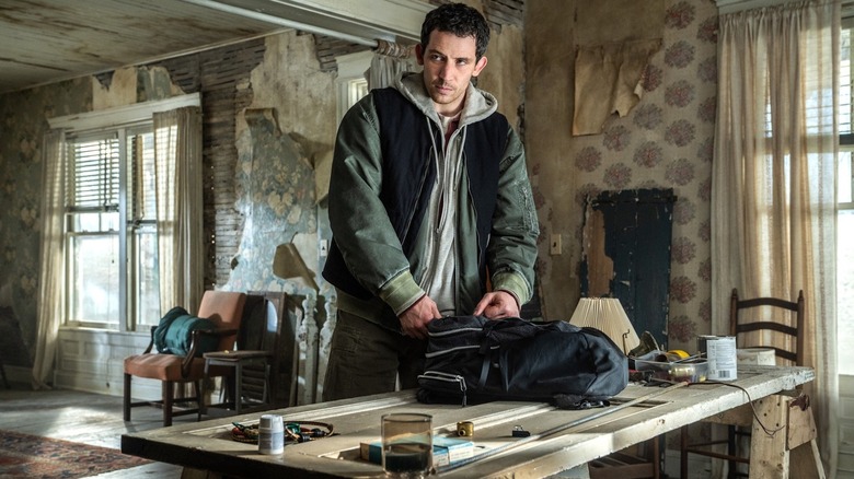 Jack O'Connell în rolul lui Daniel Kellner sortează un rucsac pe o masă de bucătărie în Disclosure Day