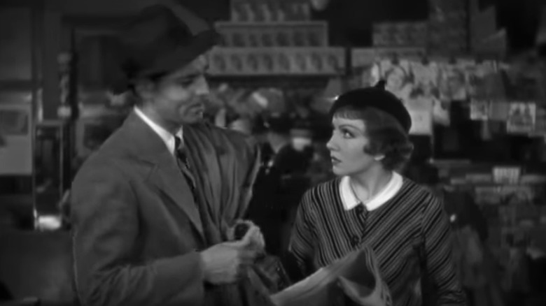 Peter Warne de Clark Gable stă lângă Ellen Andrews a lui Claudette Colbert în timp ce citește un ziar în It Happened One Night
