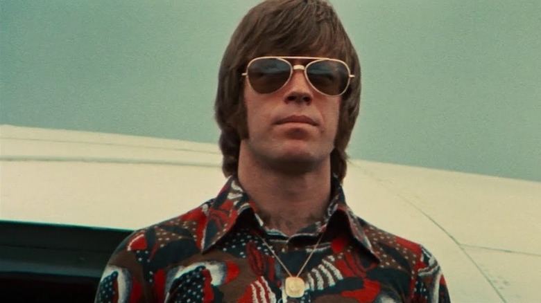 Chuck Norris în timp ce Colt coboară dintr-un avion cu ochelari de soare întunecați în Calea Dragonului