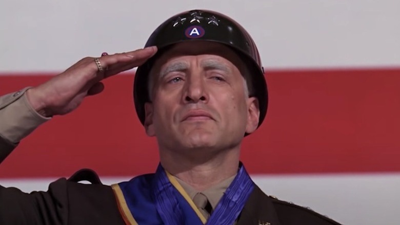 George C. Scott salută în fața unui steag american ca generalul George S. Patton în Patton