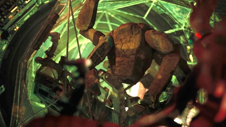 Rocky în bila sa de xenonită cu lumină verde venind din spatele lui în Project Hail Mary