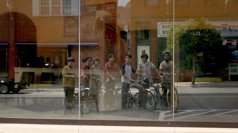 Clubul Perdanților privindu-și reflectarea mai tânără în vitrina din It: Capitolul doi