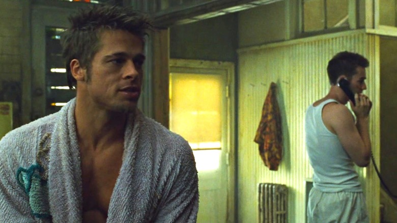 Brad Pitt în rolul lui Tyler Durden în halat de baie și Edward Norton în rolul naratorului la telefon în spatele lui în Fight Club