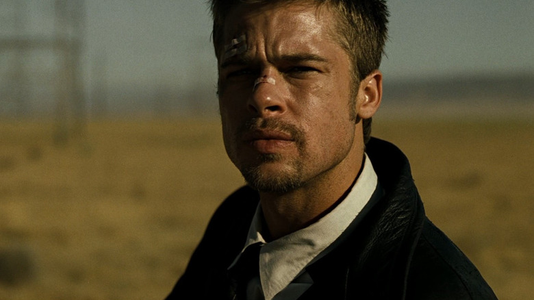 Brad Pitt în rolul detectivului David Mills, stând pe un câmp, arătând foarte îngrijorat în Se7en