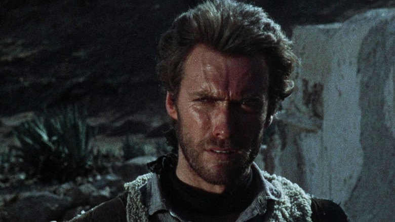 Omul fără nume al lui Clint Eastwood este văzut în prim-plan în timp ce stă afară noaptea în A Fistful of Dollars