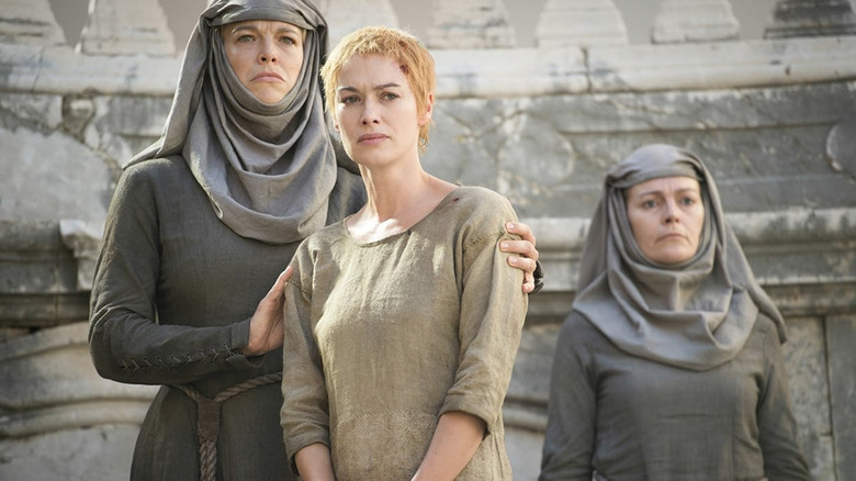 Lena Headey în rolul lui Cersei Lannister se pregătește să facă o plimbare de ispășire în timp ce este înconjurată de două septe în Game of Thrones