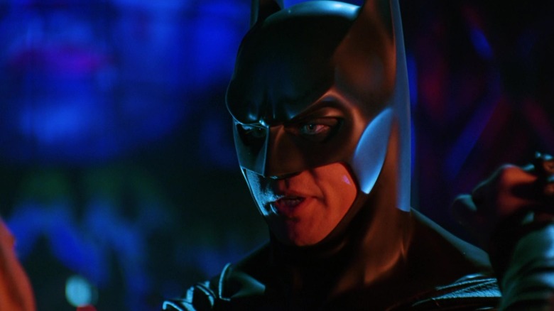 Batmanul lui Val Kilmer se află pe o alee iluminată cu neon din Batman Forever