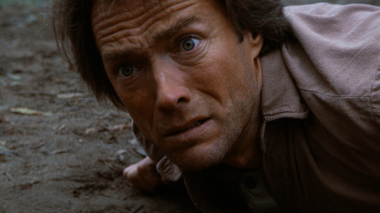 Josey Wales, întins pe pământ, arătând alarmat în The Outlaw Josey Wales