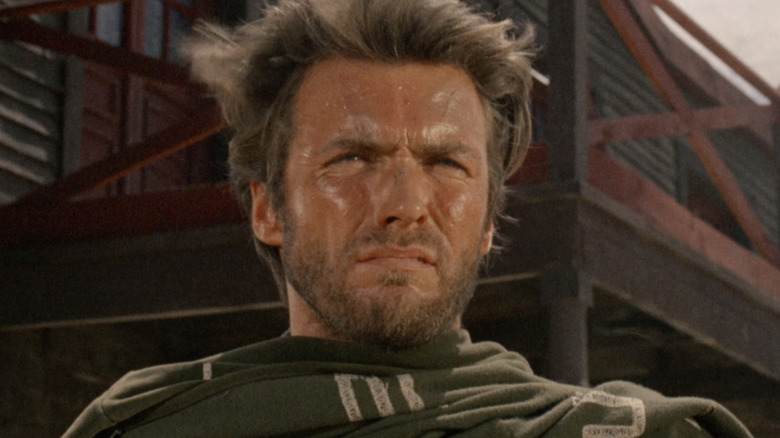 Omul fără nume al lui Clint Eastwood stă afară privind în depărtare în A Fistful of Dollars