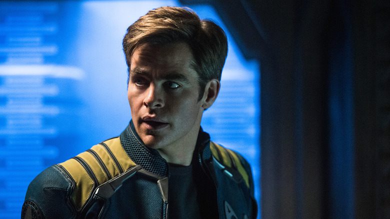 Chris Pine în rolul căpitanului Kirk, în jacheta albastră, care se uită în dreapta sa în Star Trek Beyond