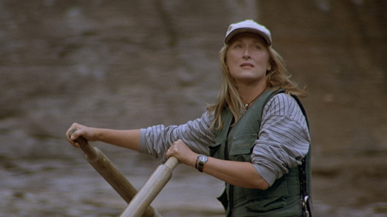 Gail Hartman din Meryl Streep ridică privirea în timp ce conduce o plută în The River Wild