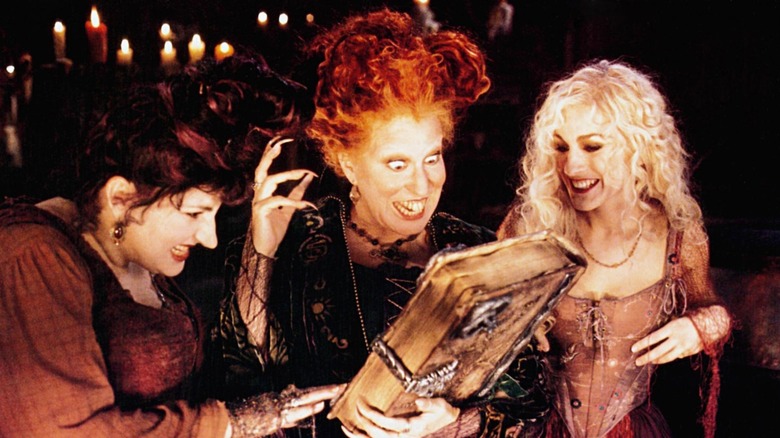Kathy Najimy, Bette Midler și Sarah Jessica Parker uitându-se la cartea lor de vrăji din Hocus Pocus