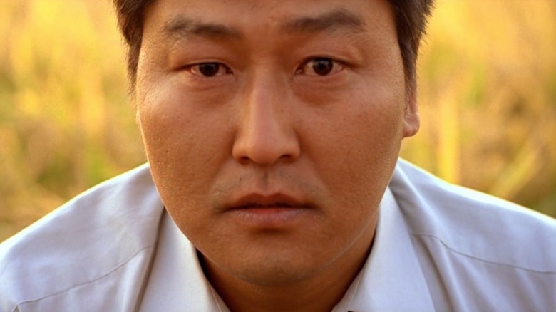 Song Kang-ho în rolul lui Park Doo-man se uită direct la cameră