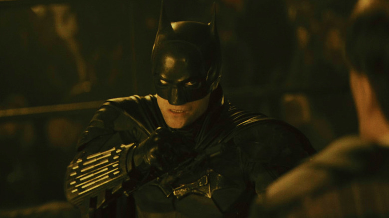 Batmanul lui Robert Pattinson stă cu pumnii ridicati în Iceberg Lounge din The Batman