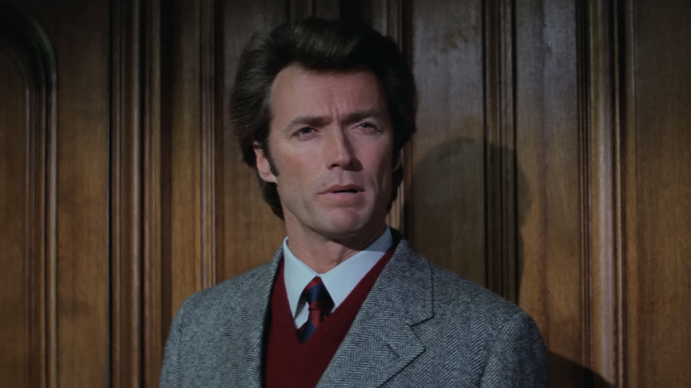 Harry Callahan al lui Clint Eastwood stă lângă un perete cu lambriuri de lemn în Harry murdar