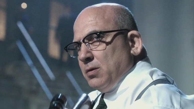 Jonny Coyne ca gardianul Edwin James ținând o pușcă în Alcatraz