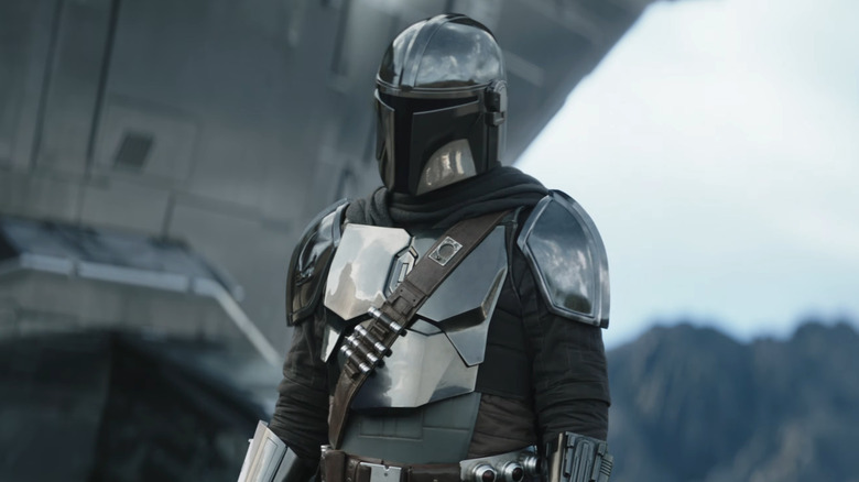 Mando stând lângă noul său Razor Crest în The Mandalorian și Grogu