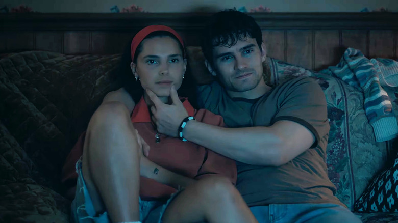 Inde Navarrette ca Nikki stând pe canapea lângă Michael Johnston ca Ursul ținându-și bărbia în Obsession